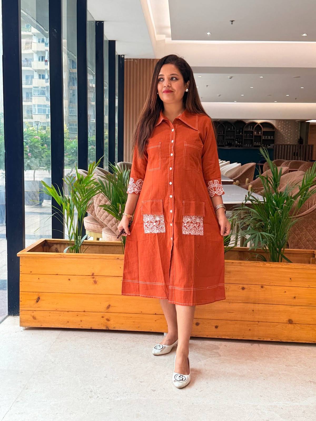 Cotton rust-orange collared shirt-style dress white contrasting stitch details and intricate floral embroidery on the sleeve cuffs and pockets