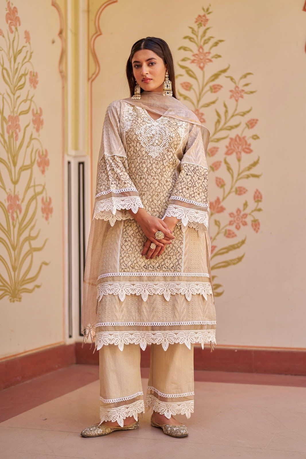 Pakistani-style three-piece suit featuring a net overlay tunic adorned with white lace trim along the sleeves and hemline, paired with matching solid wide-leg trousers and a light dupatta