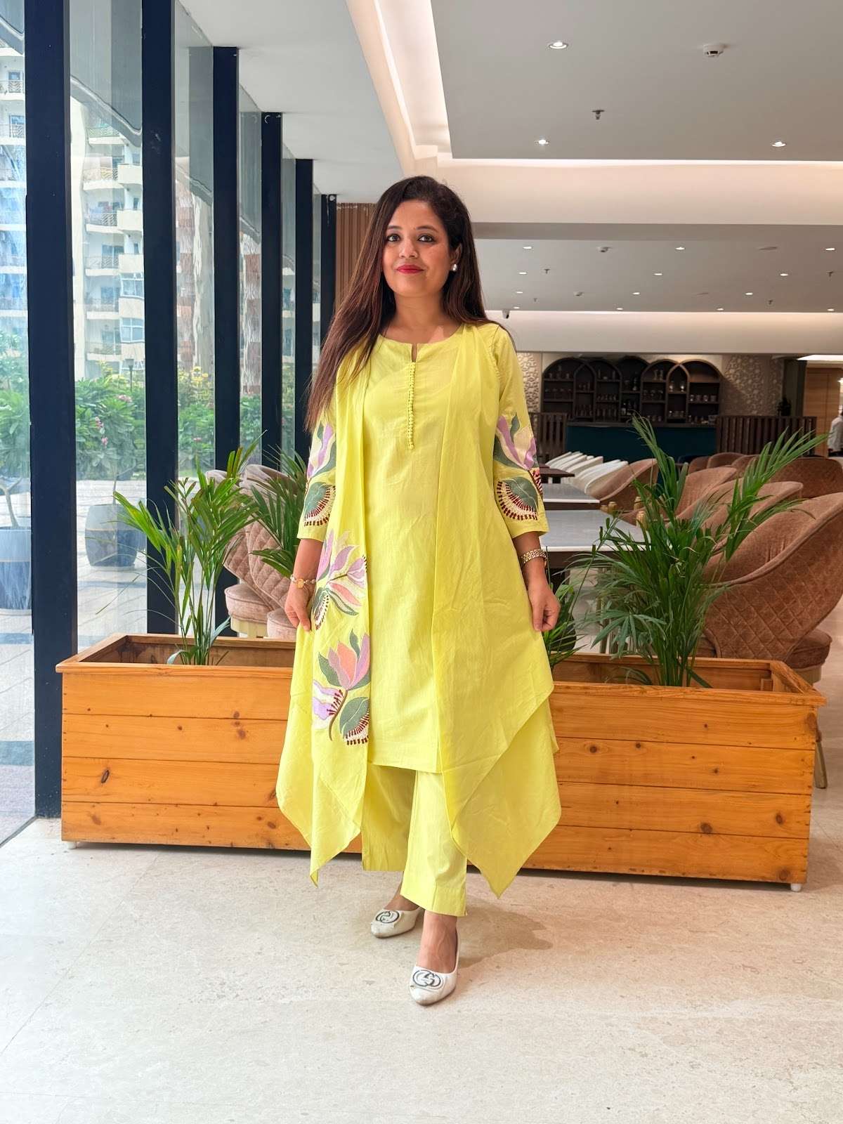 cotton lime green kurta set featuring an elegant, asymmetrical layered design with delicate floral embroidery on the front panel and sleeves, complete with a button-detail neckline