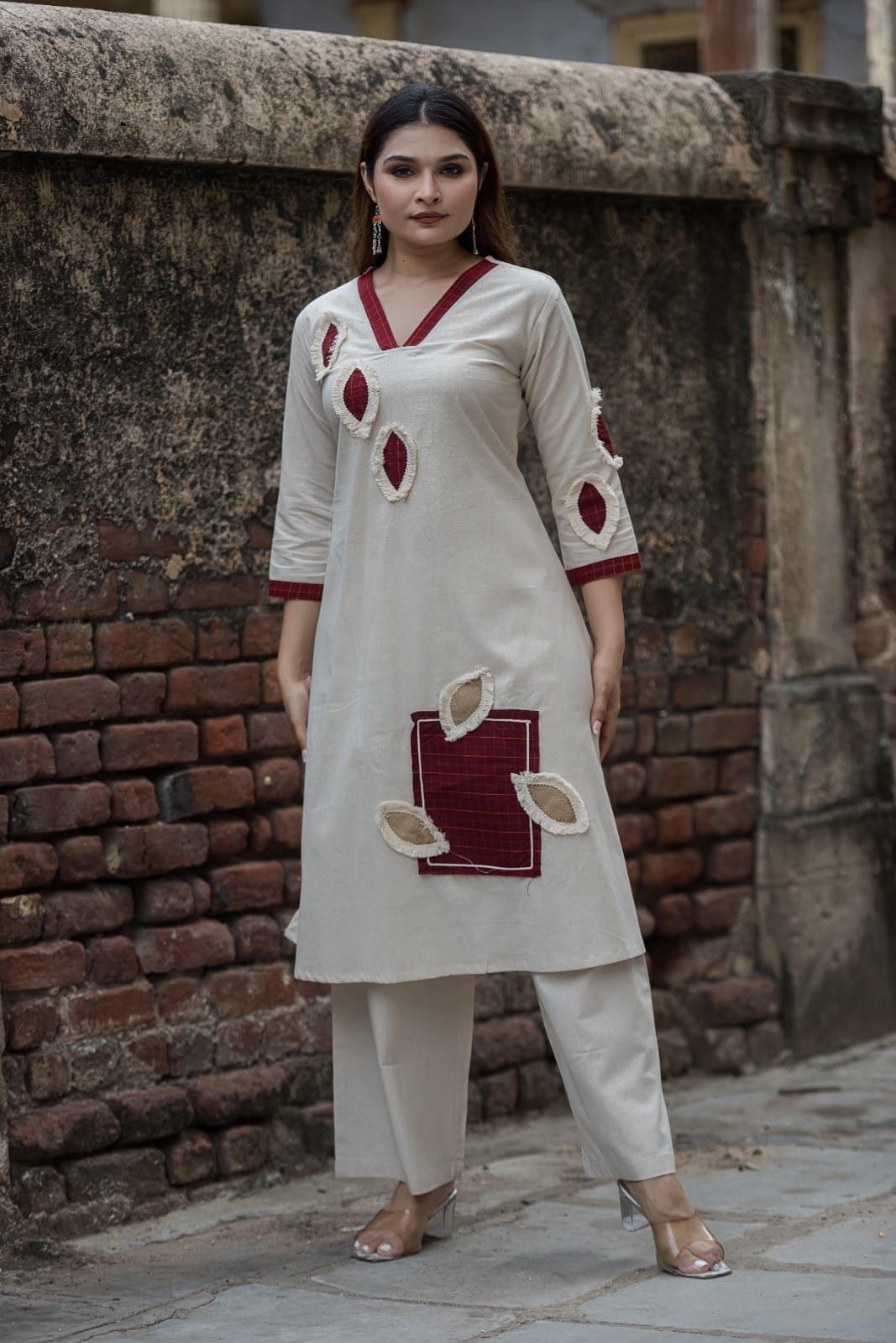 Flex cotton  kurta set features unique jute applique patchwork and maroon V-neck detailing