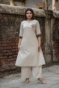 Off White cotton blend kurta and palazzo set featuring contrast plaid sleeve cuffs and dark chest embroidery